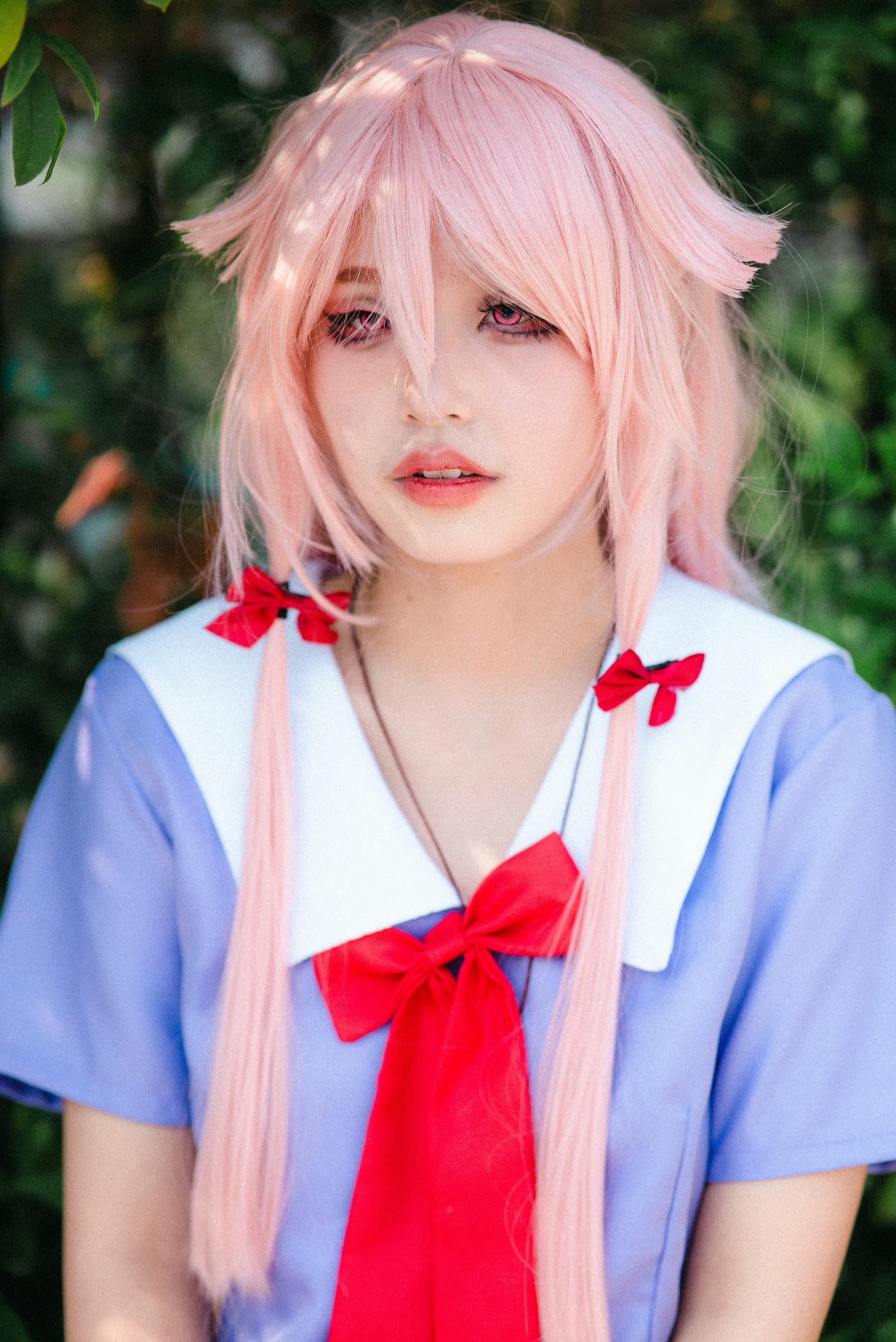 Cosplayer in pink wig and school uniform at a Tokyo anime event