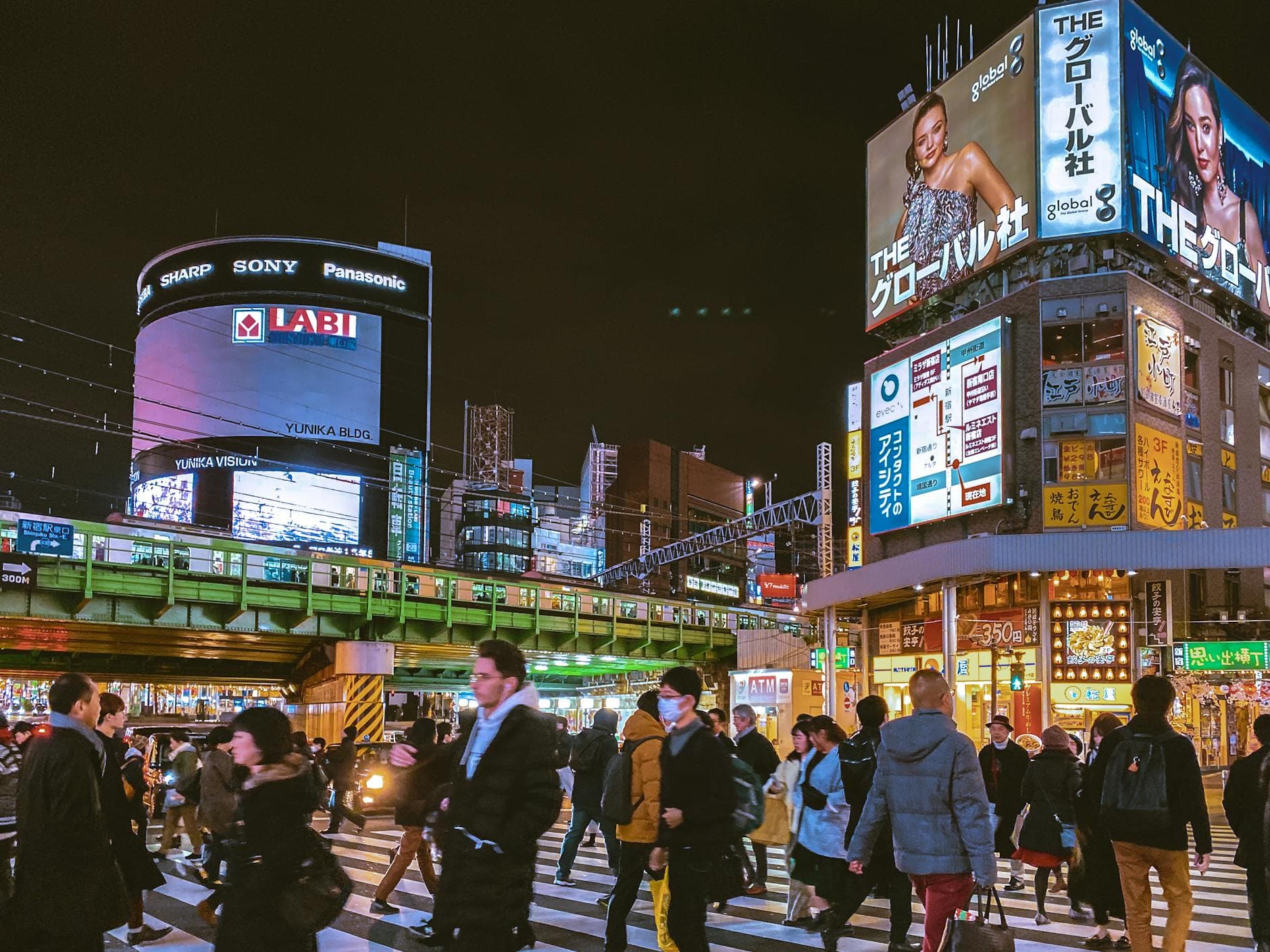 Busy Shibuya crossing at night with crowds and glowing billboards