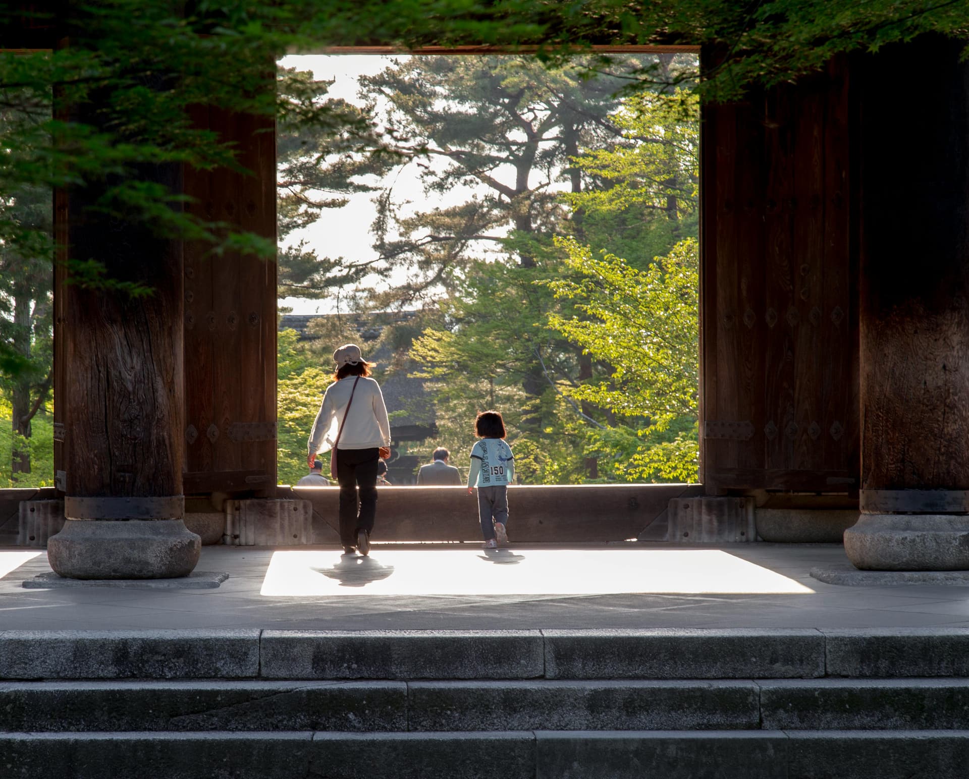 Mother and child walking through temple gate