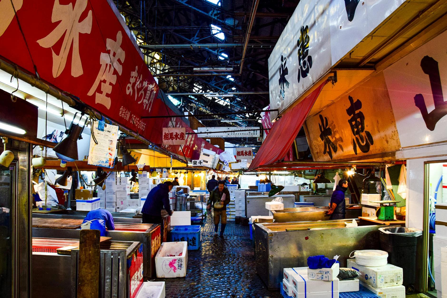 Vendors and shoppers at Tsukiji fish market stalls at night