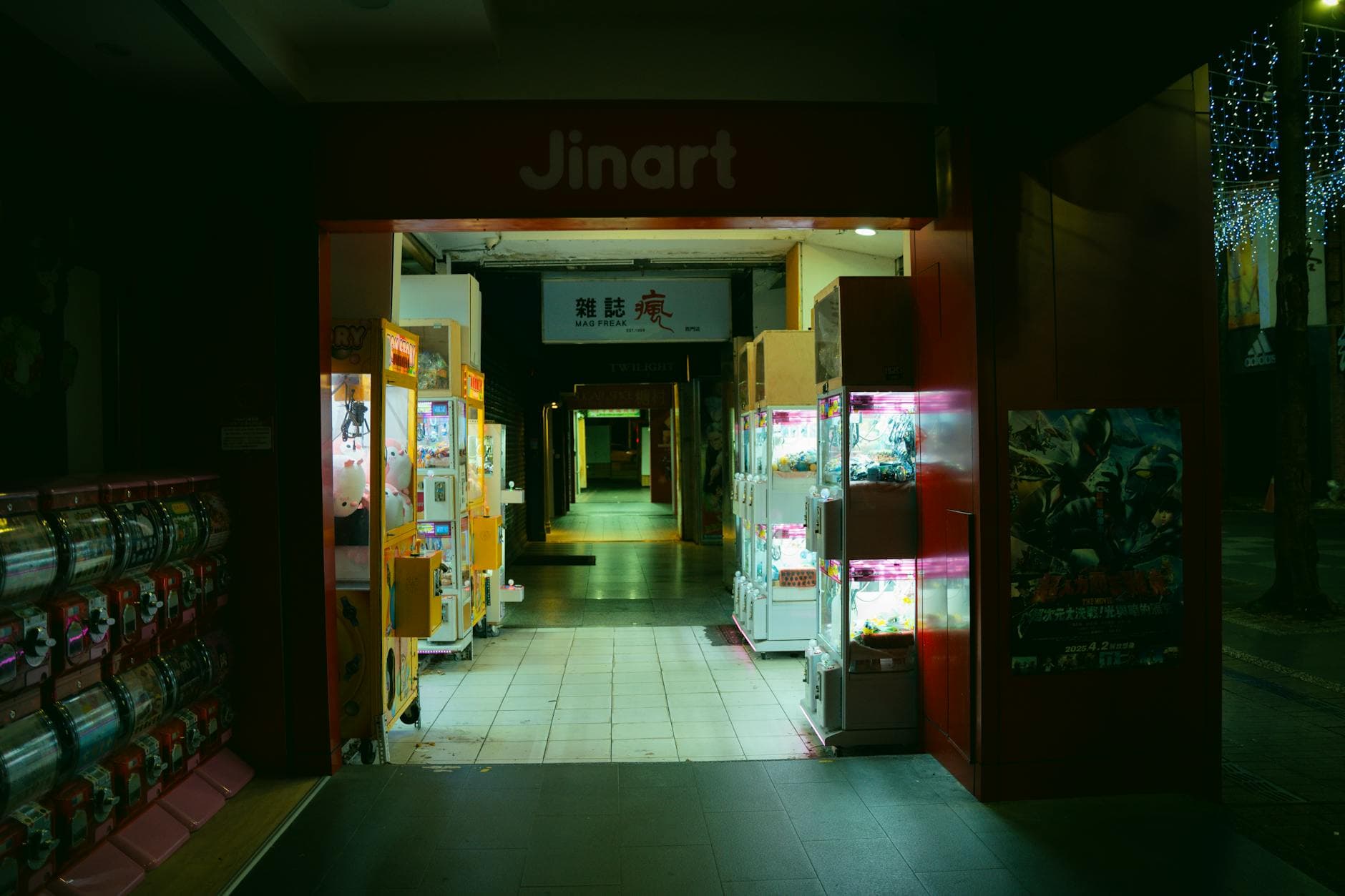 Colorful arcade entrance at night with rows of vending and gachapon machines