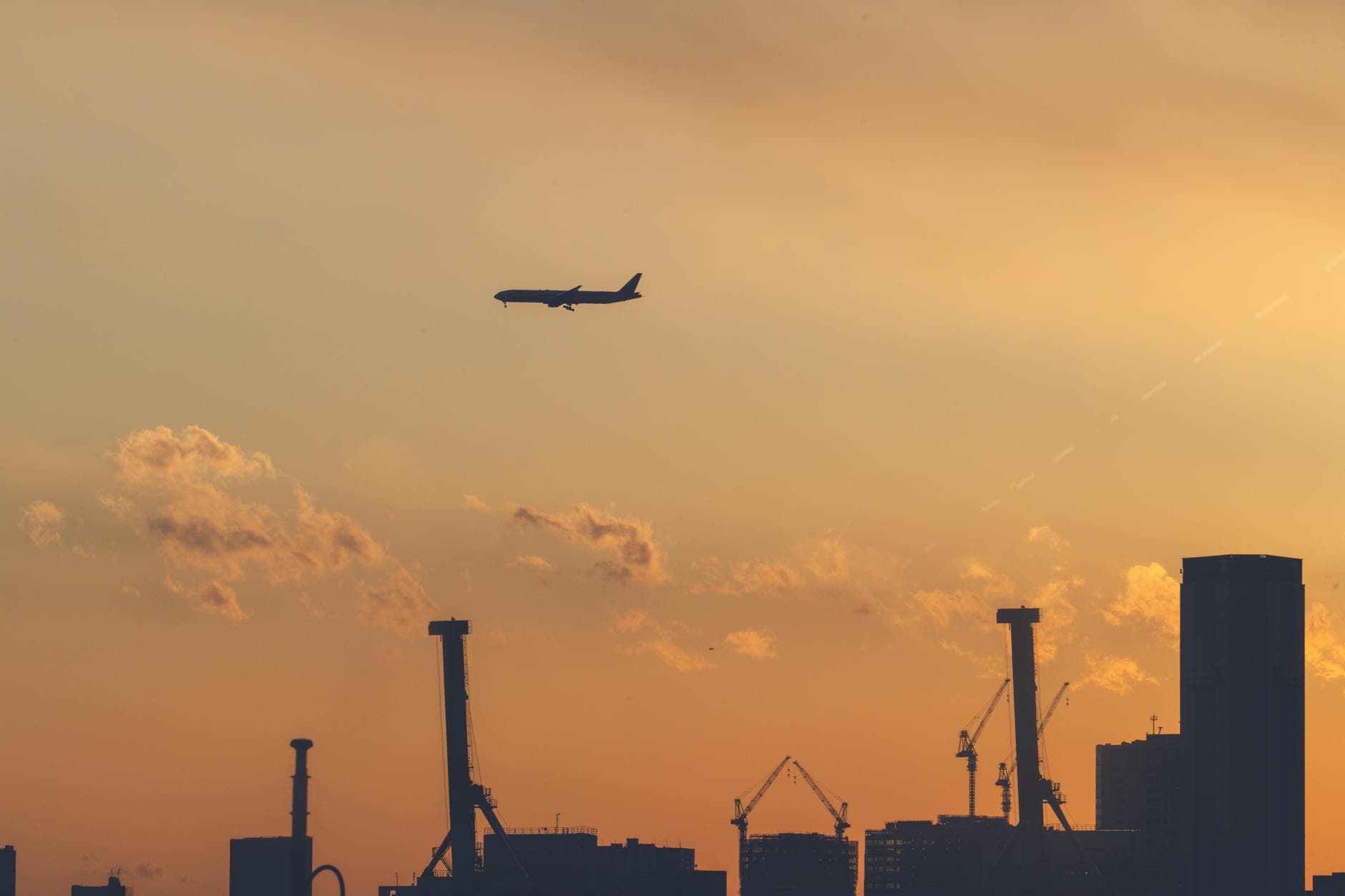Tokyo skyline silhouette with airplane during golden hour