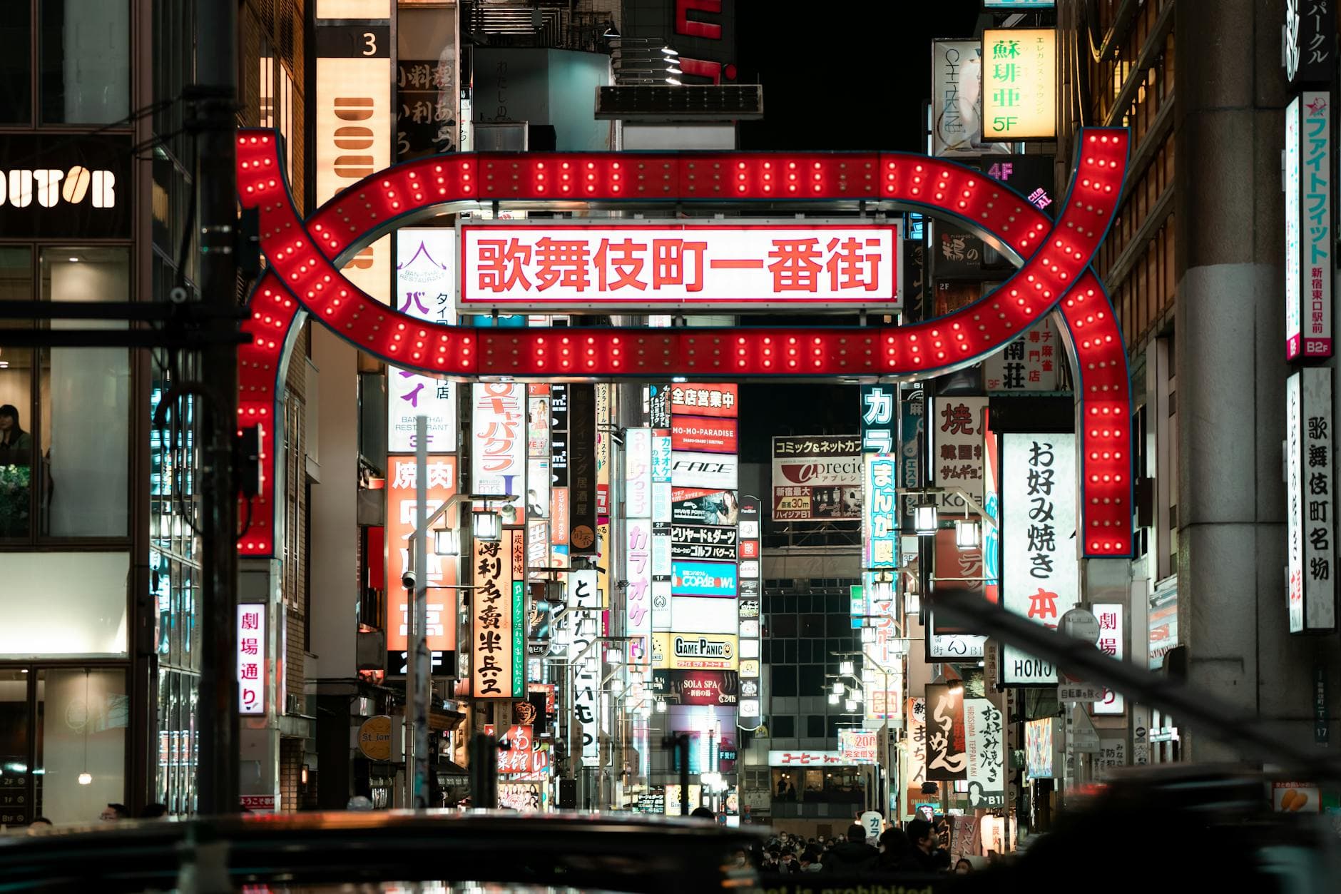 Kabukicho neon signs and red entrance arch on busy Tokyo street