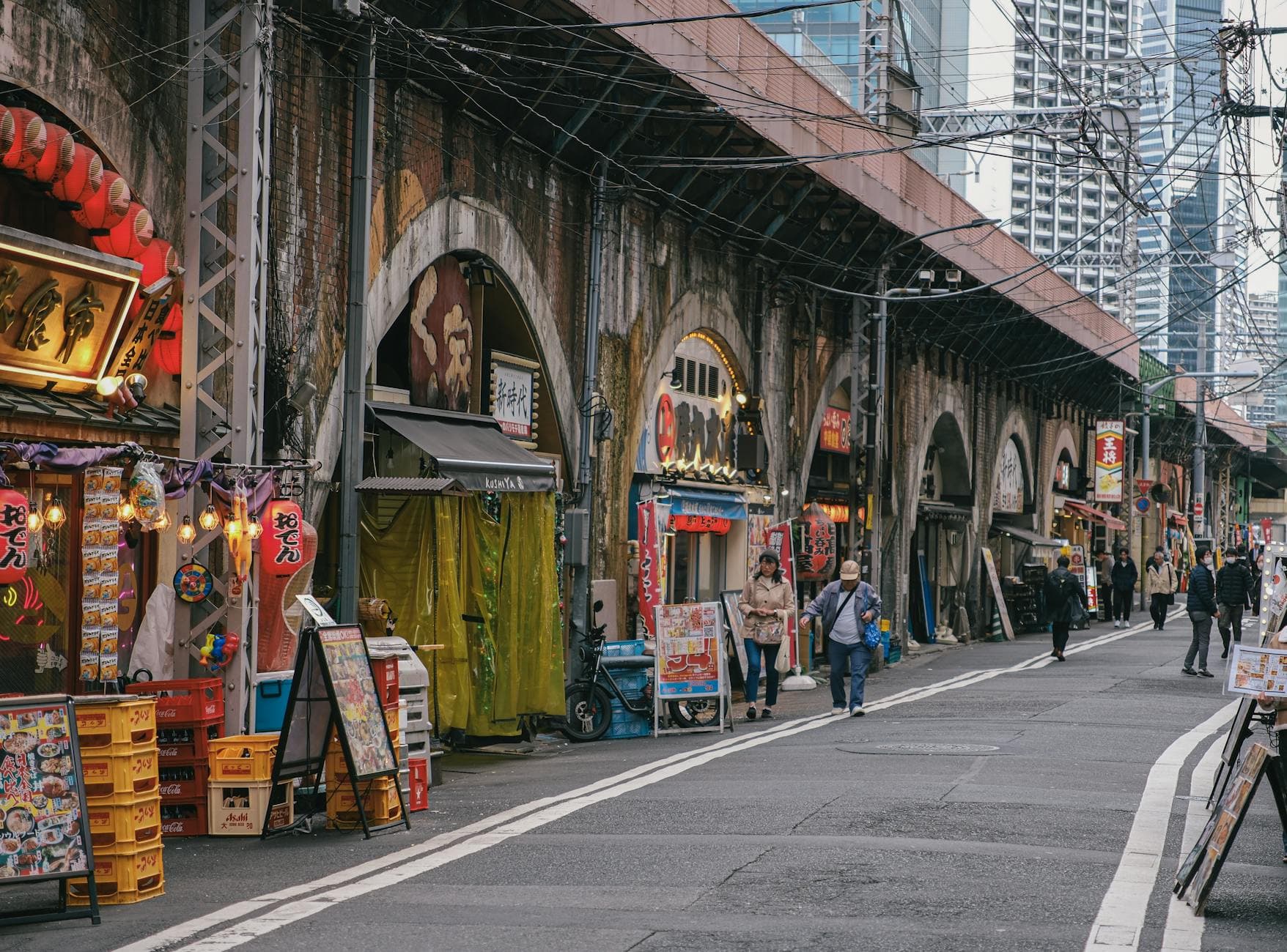 Tokyo shopping alley under railway arches with izakaya signs