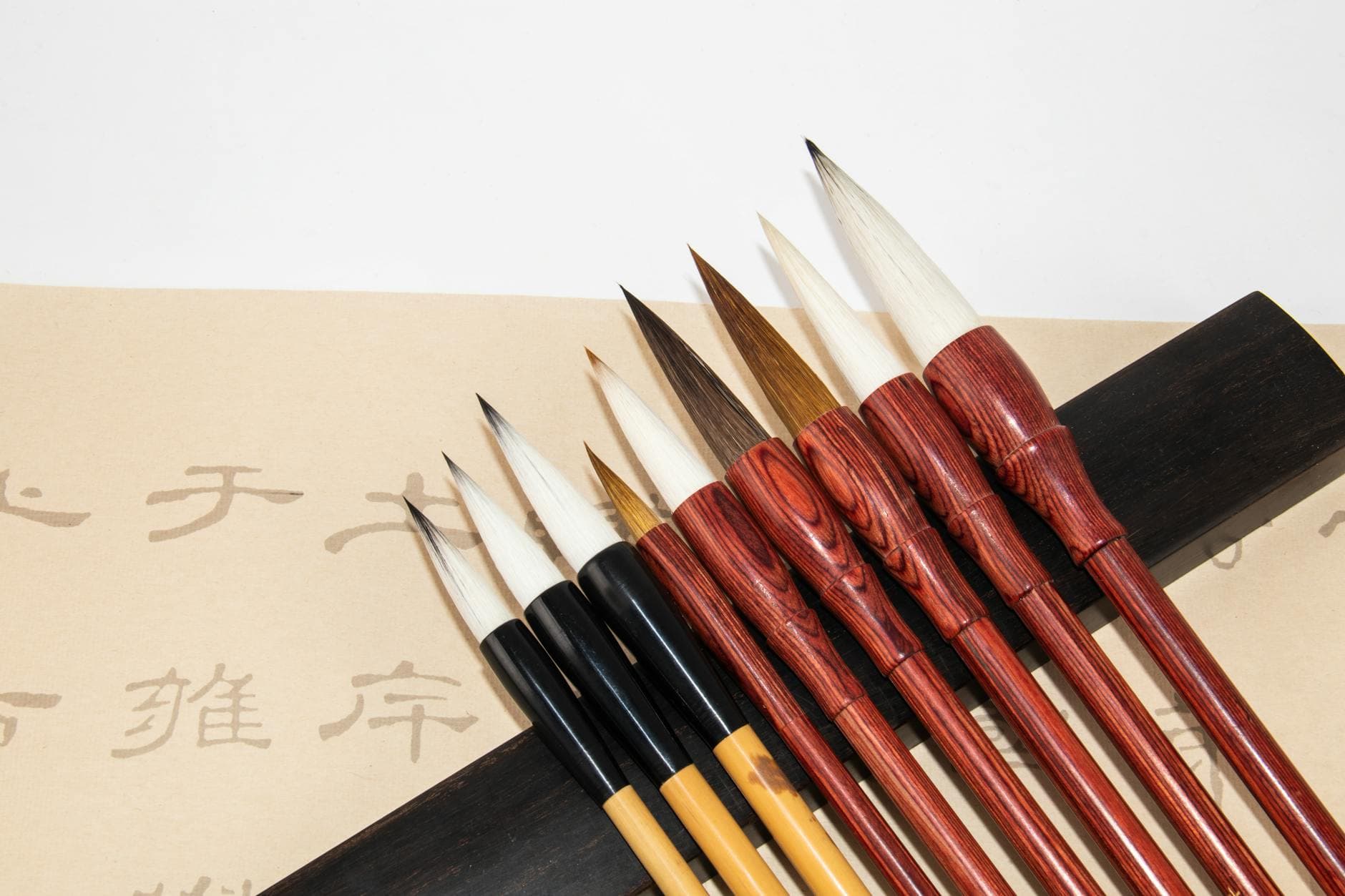 Traditional Japanese calligraphy brushes with pointed tips arranged on a white surface