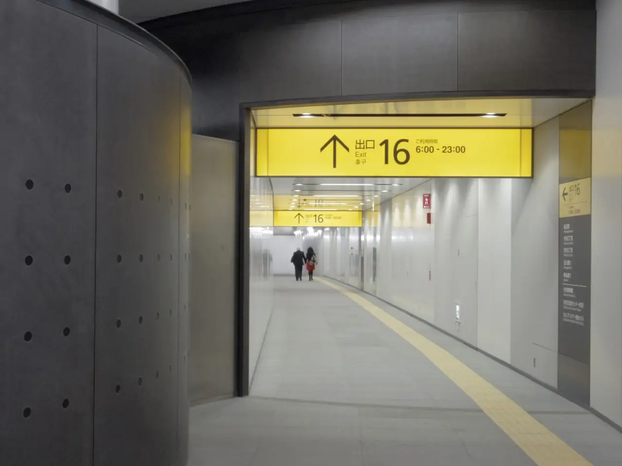 Yellow sign pointing to Exit 16 in an underground passage at Shibuya Station