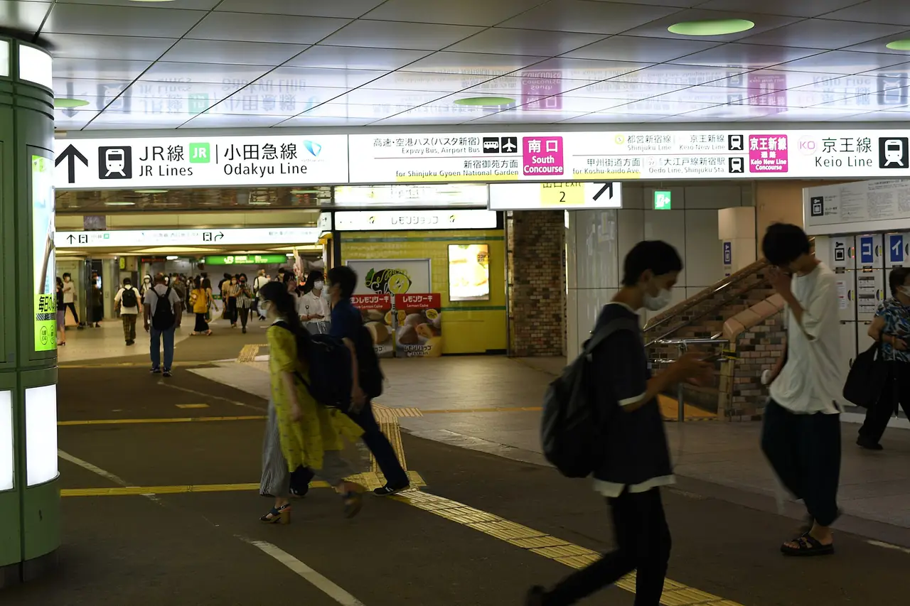 Signs for the JR, Odakyu and Keio lines over a passageway in Shinjuku Station