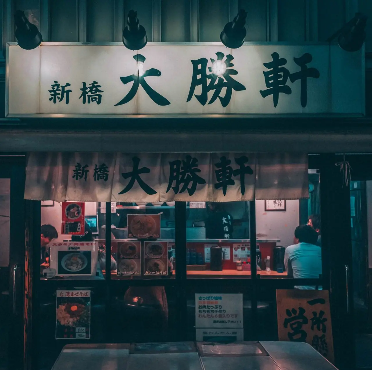 Lit storefront of a small noodle shop in Shinbashi, Tokyo, at night