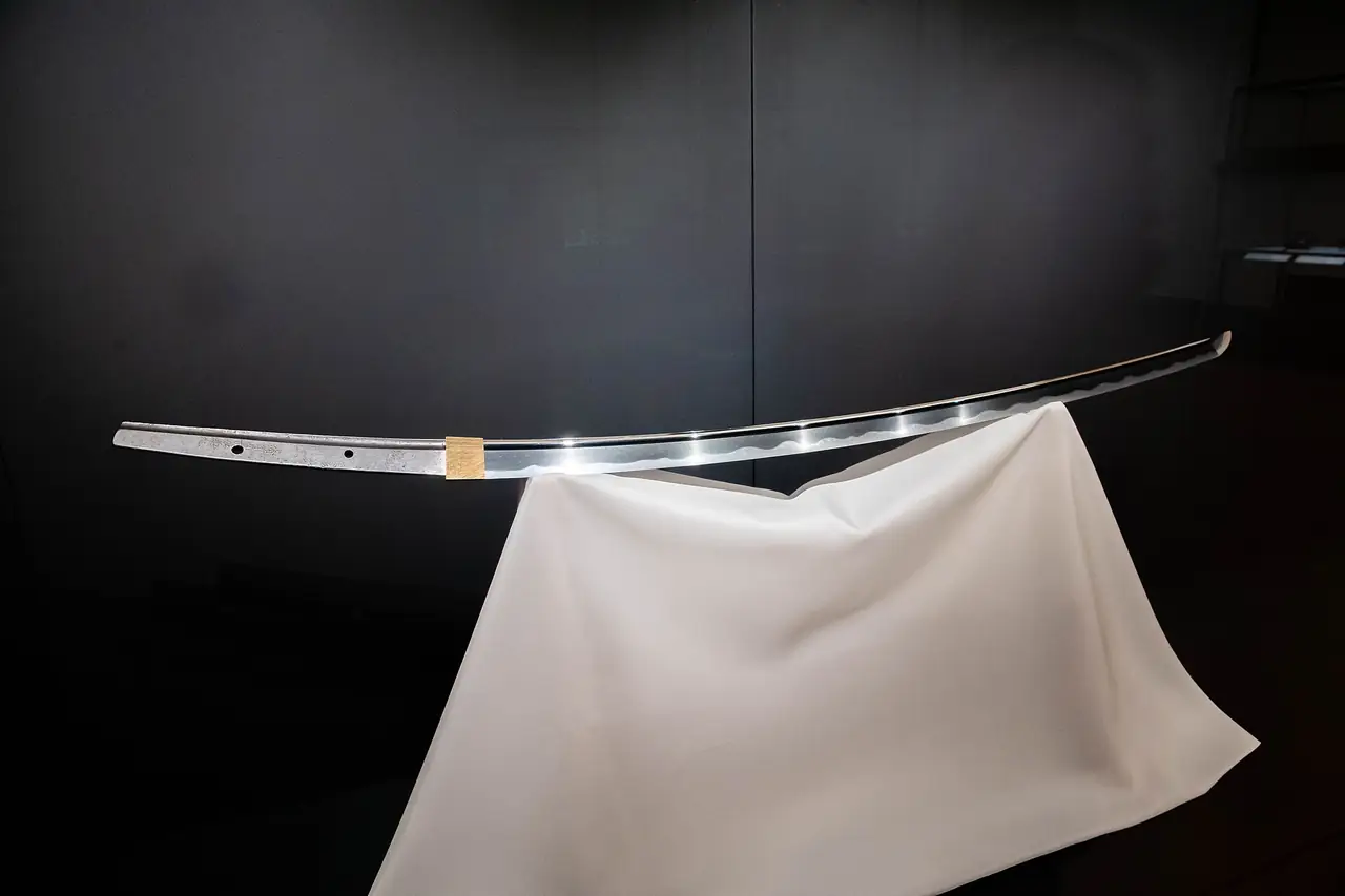 A Japanese sword blade displayed on white cloth in the Honkan of the Tokyo National Museum