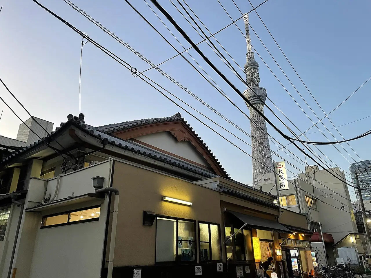 Daikoku-yu bathhouse in Oshiage with Tokyo Skytree rising behind it at dusk