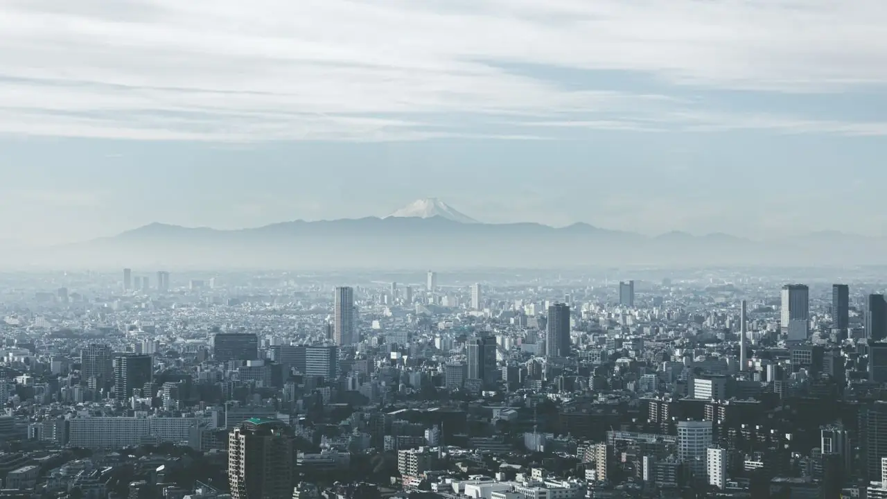 Mount Fuji rising far beyond the Tokyo skyline on a hazy day