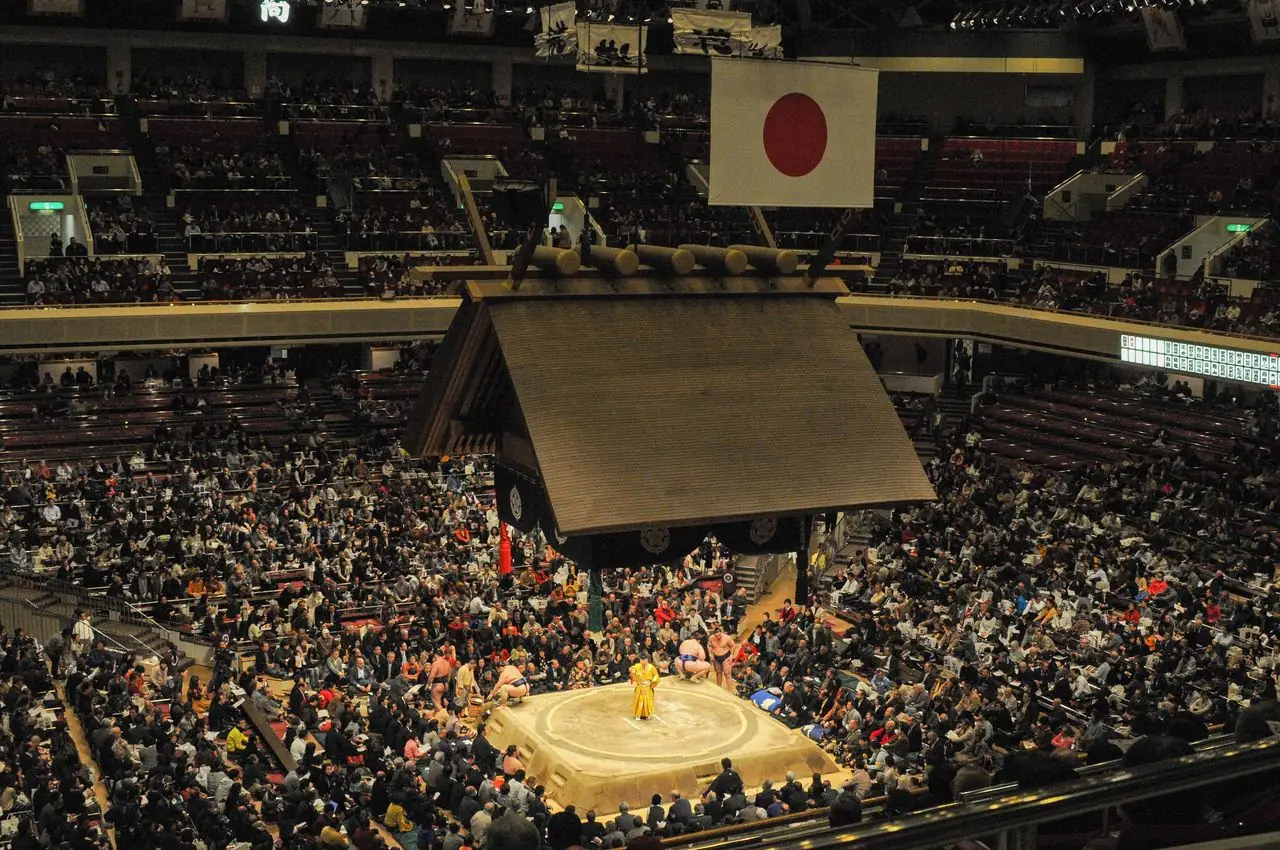 Packed seats around the dohyo and its hanging roof during a tournament at the Kokugikan