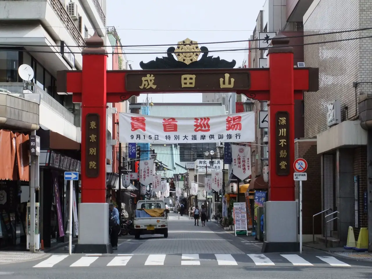 Red Naritasan gate over the shop-lined approach road to Fukagawa Fudo-do