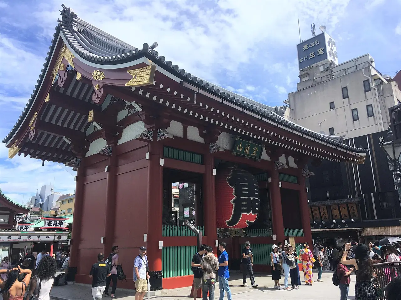 Visitors outside the Kaminarimon gate of Sensoji Temple in Asakusa on a sunny day