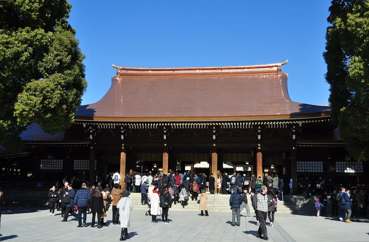 Worshippers gathered before the main hall of Meiji Shrine on a clear day