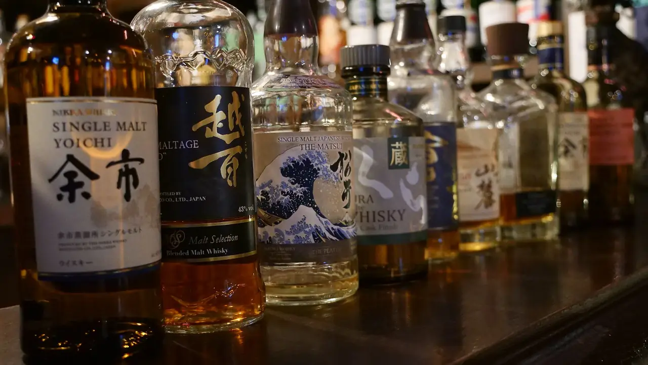 Row of Japanese whisky bottles including Nikka Yoichi lined up on a bar counter