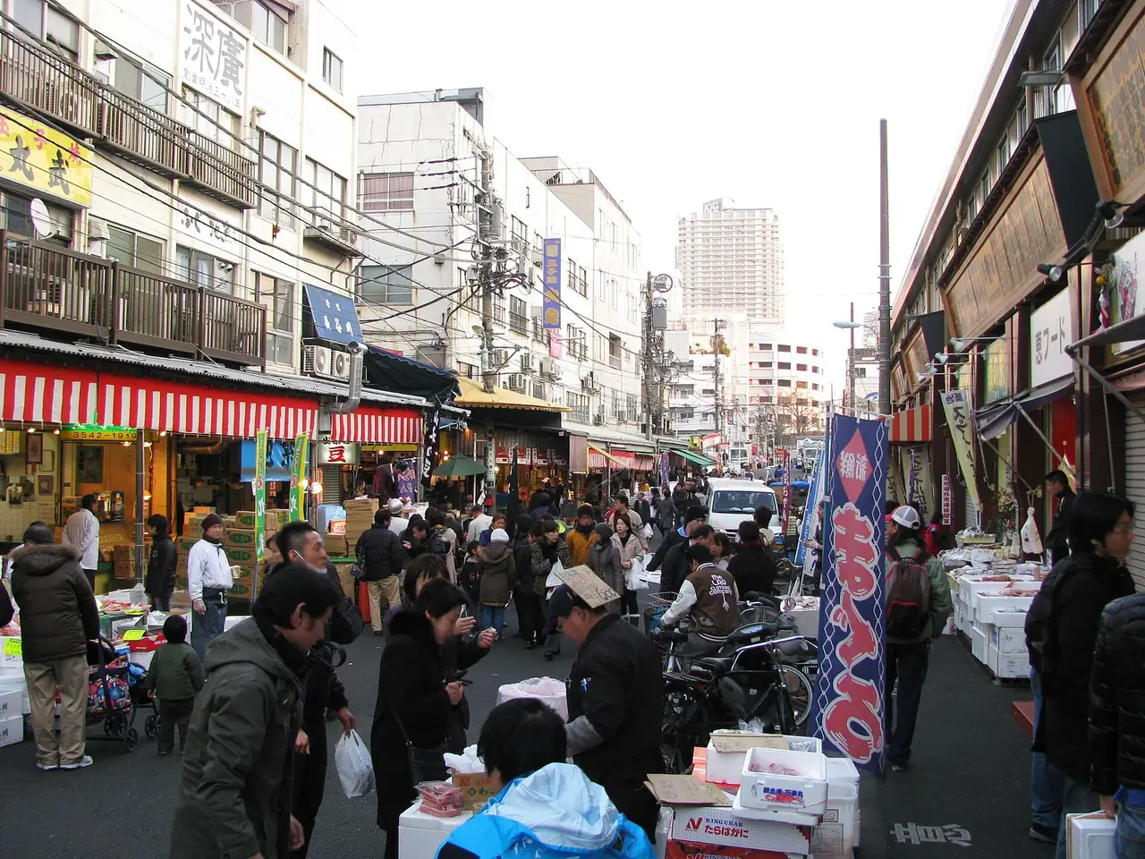 Shoppers crowding a street of seafood stalls in Tsukiji Outer Market