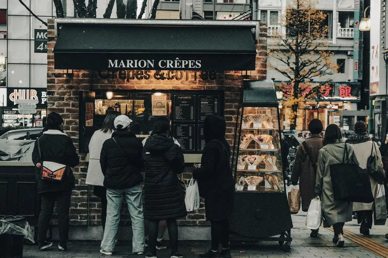 People queuing at a Marion Crepes stand on a Tokyo shopping street