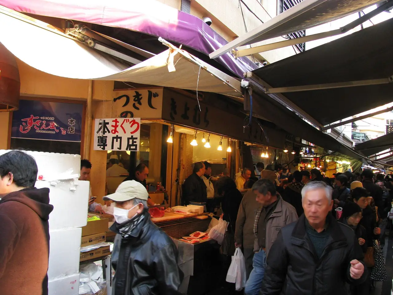 Crowds in a narrow covered lane of seafood shops at Tsukiji Outer Market