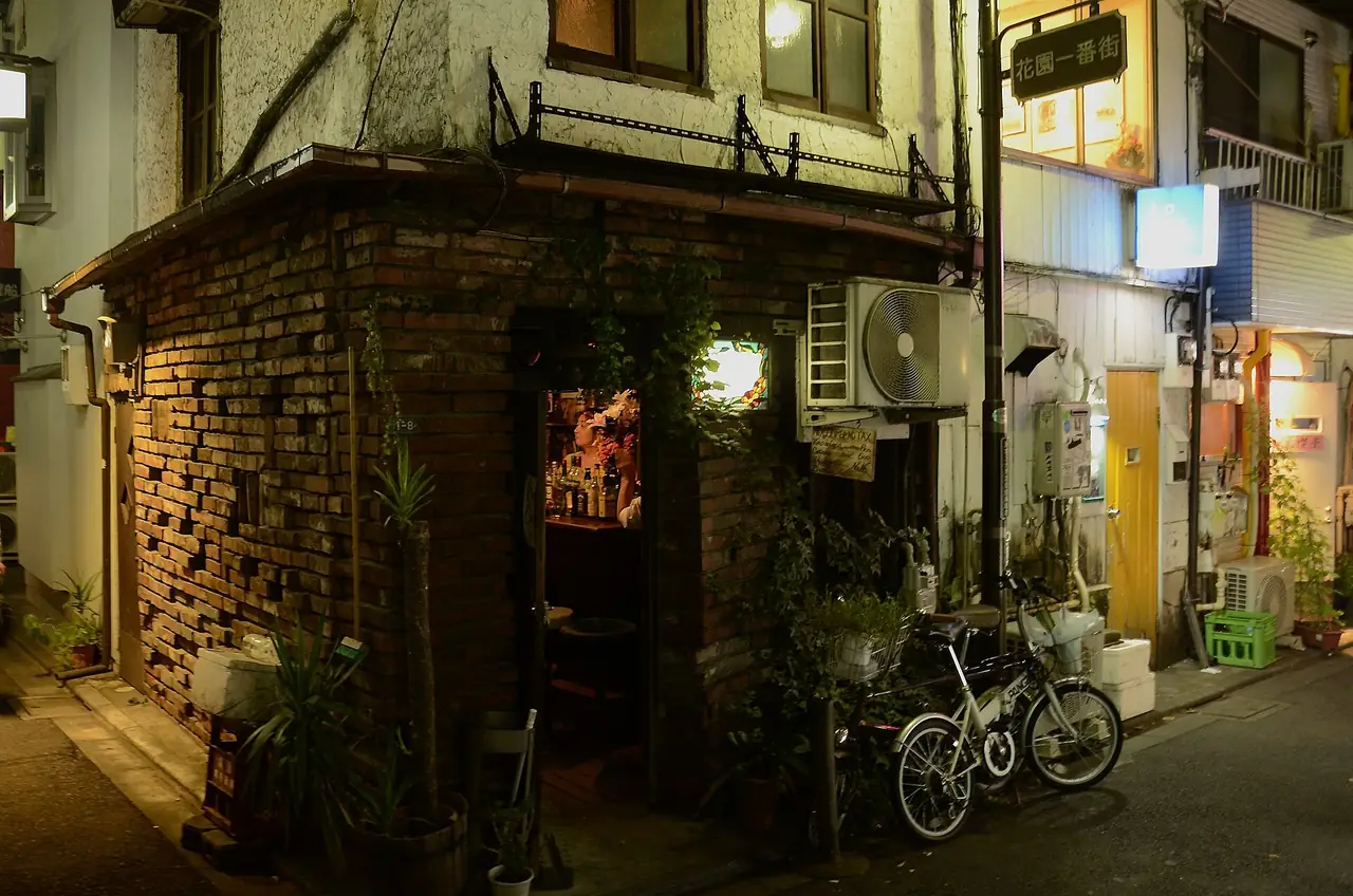 Small brick-fronted bar building on a Golden Gai corner at night