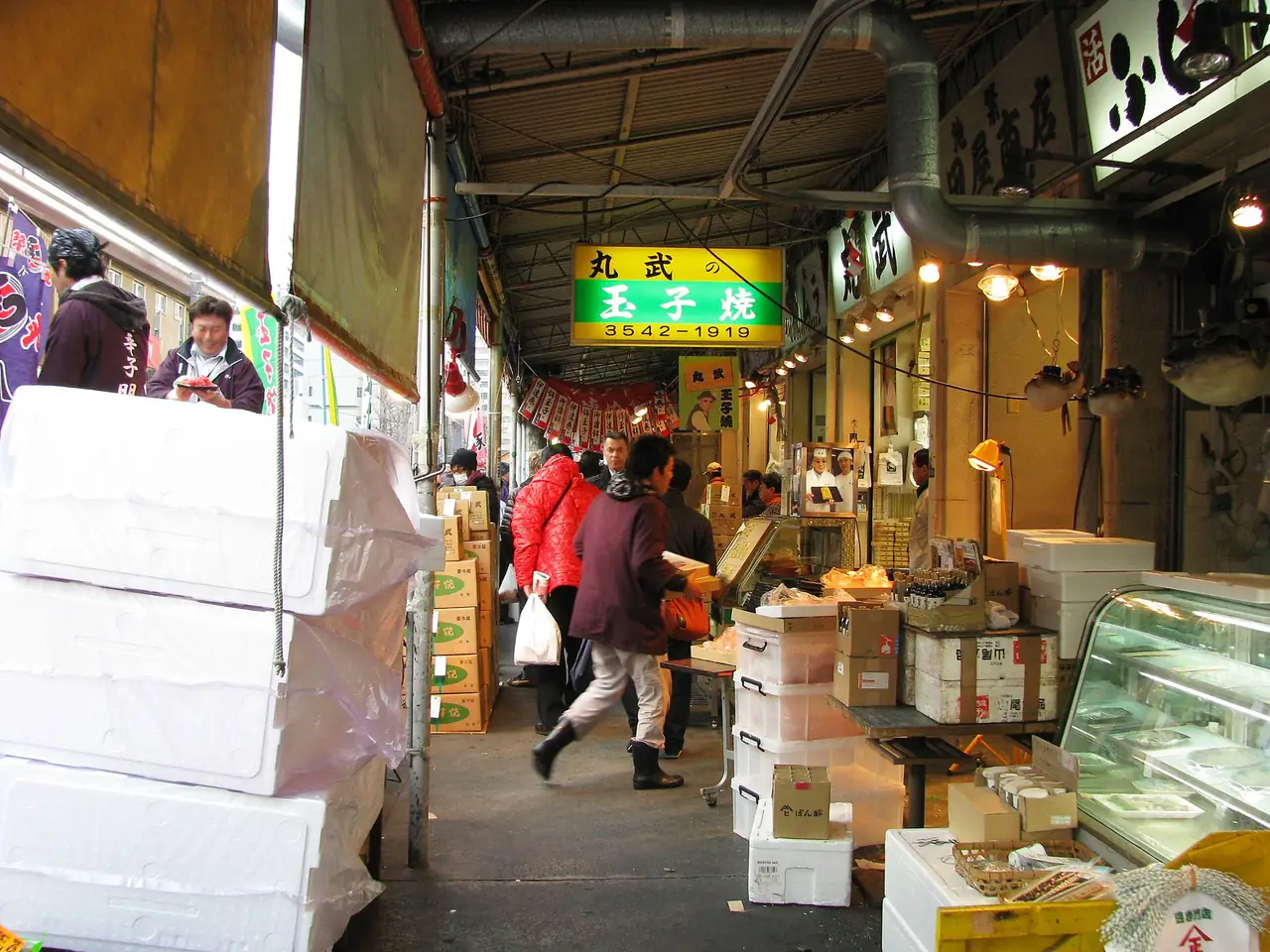 Shoppers in a covered lane by the Marutake tamagoyaki stall at Tsukiji Outer Market