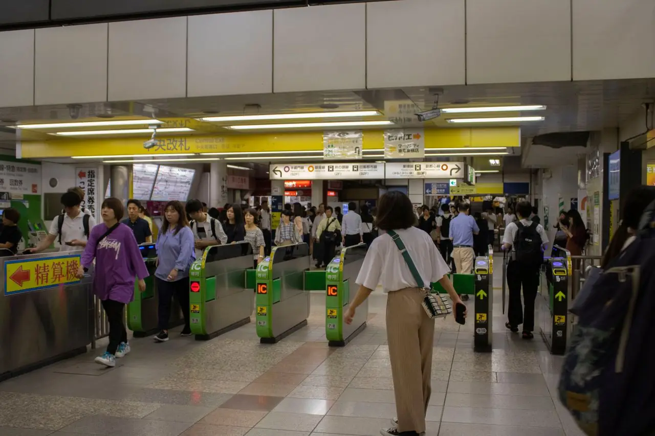 Commuters passing through the JR ticket gates at the central exit of Shibuya Station
