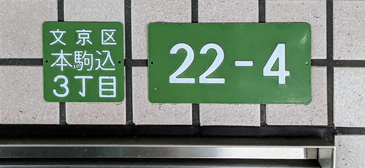 Green address plates for Honkomagome 3-chome in Bunkyo with block and building number 22-4