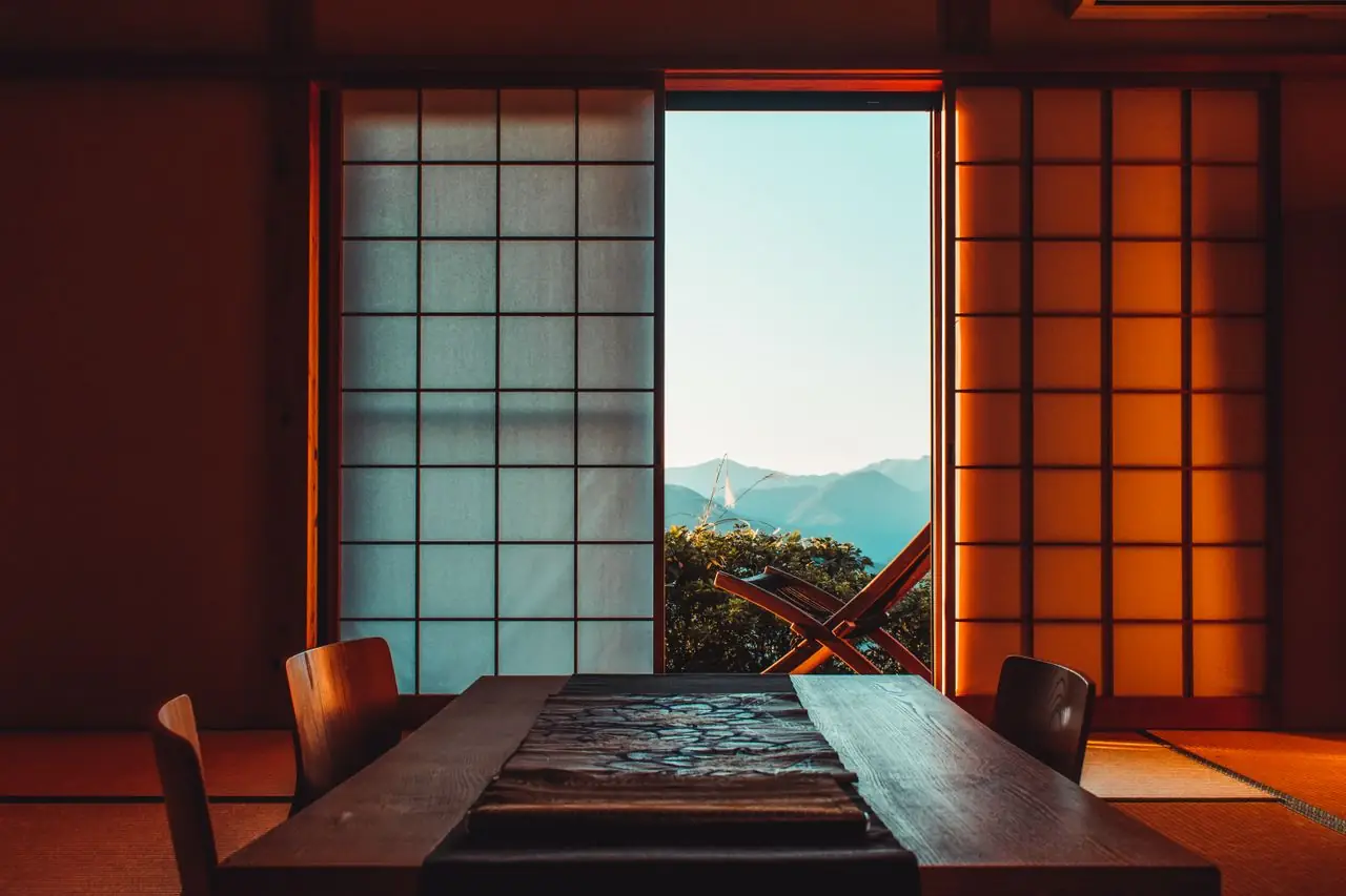 Traditional tatami room with shoji screens open onto a mountain view in Japan