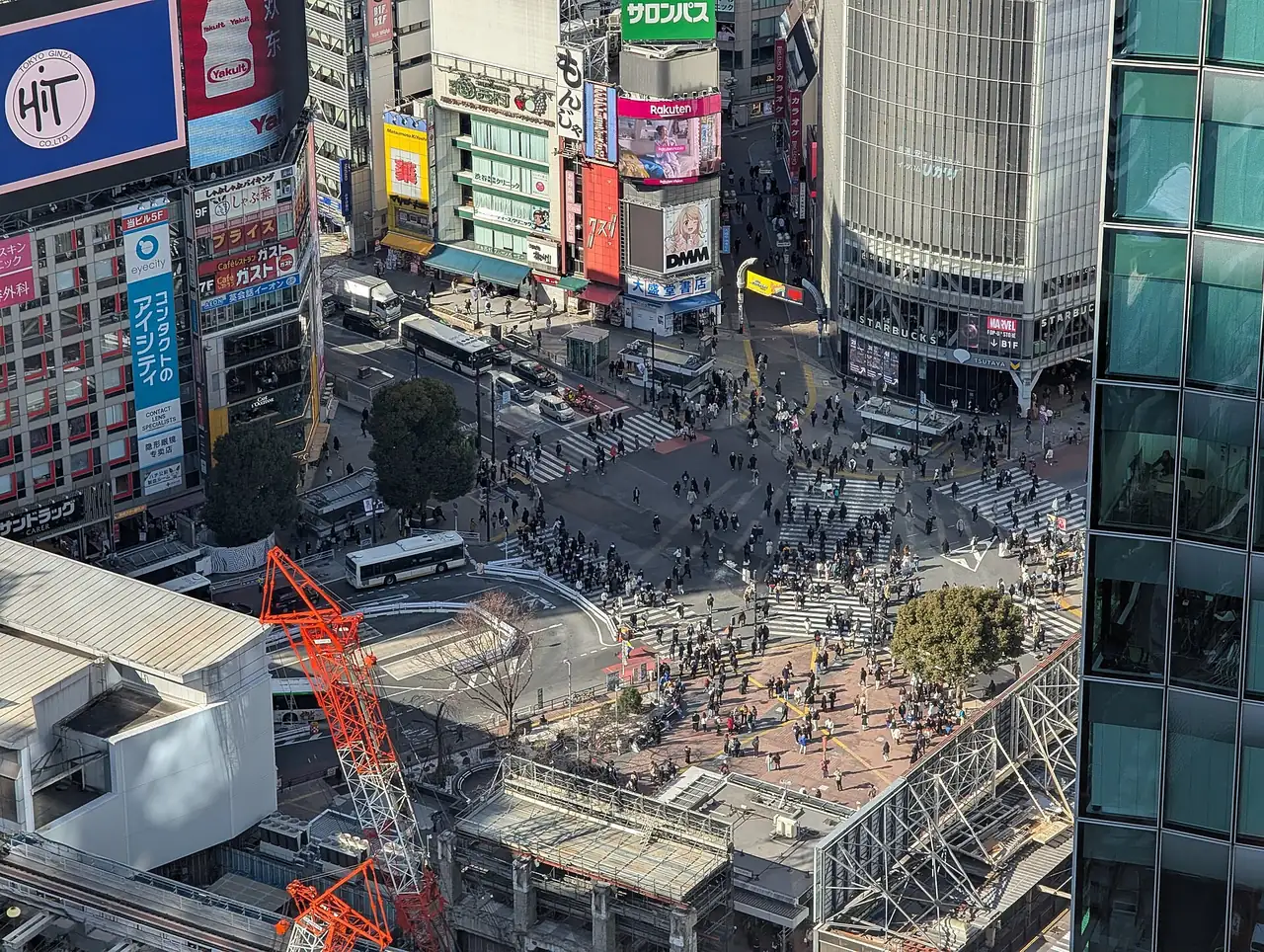 Crowds crossing Shibuya Scramble Crossing in daylight, seen from above