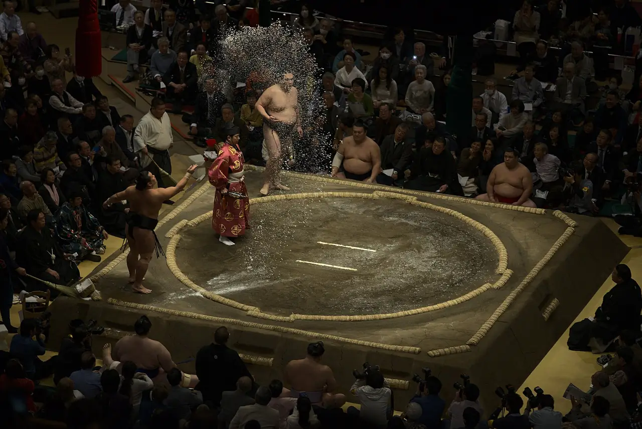 Sumo wrestler throws salt across the clay ring before a bout at Kokugikan