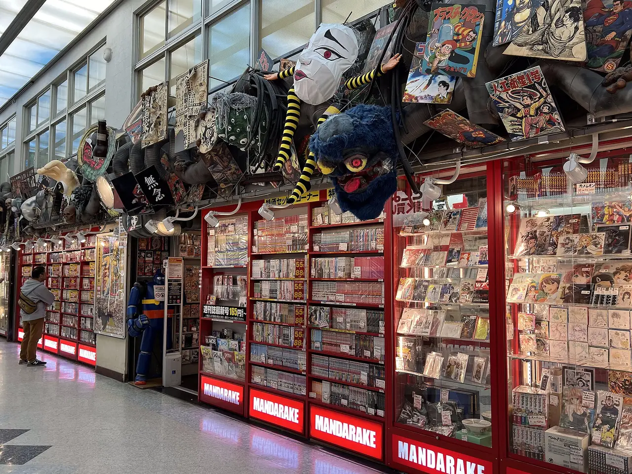 Mandarake storefront in Nakano Broadway with manga shelves and masks hung above