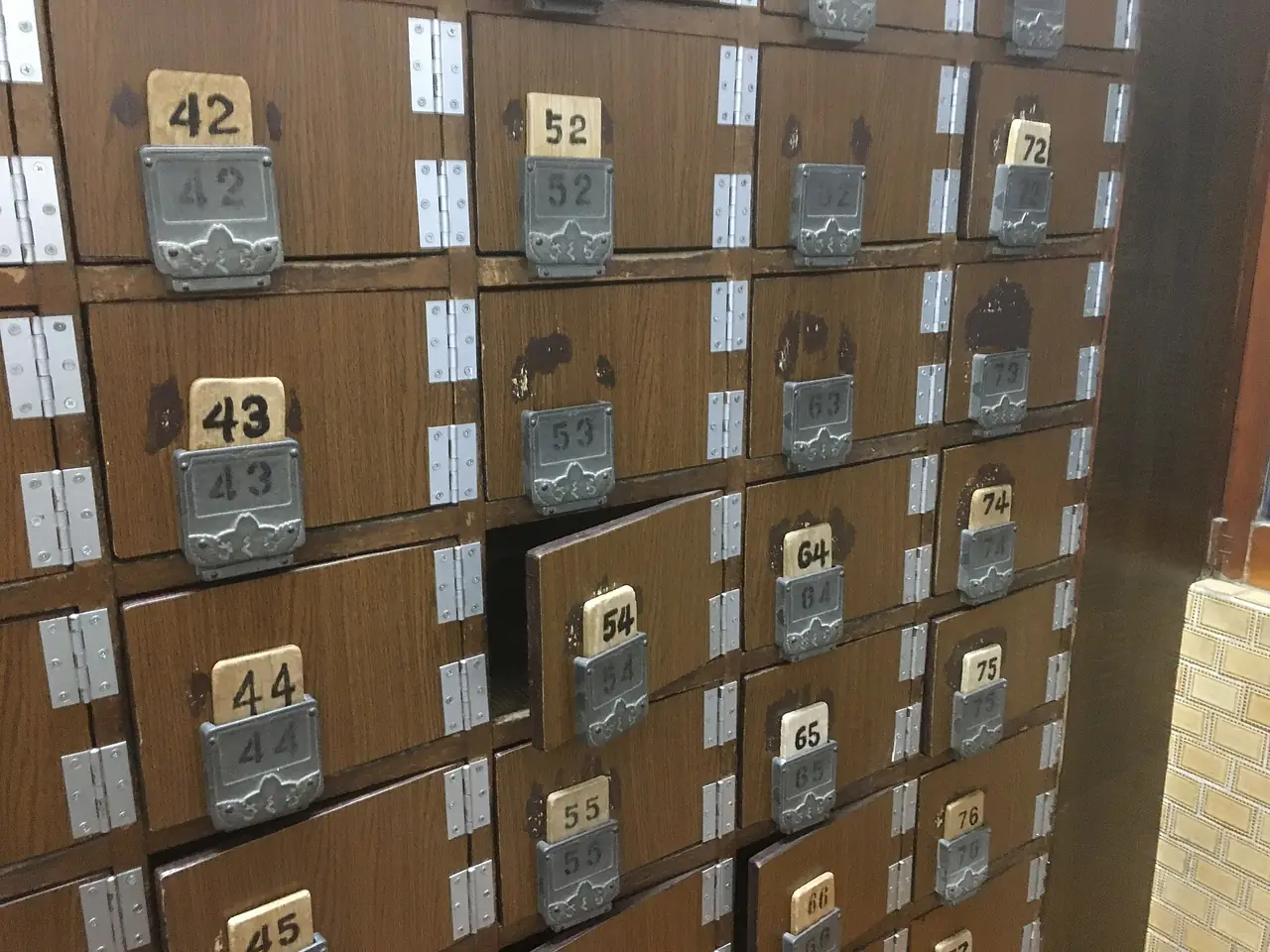 Numbered wooden getabako shoe lockers at the entrance of a neighborhood sento