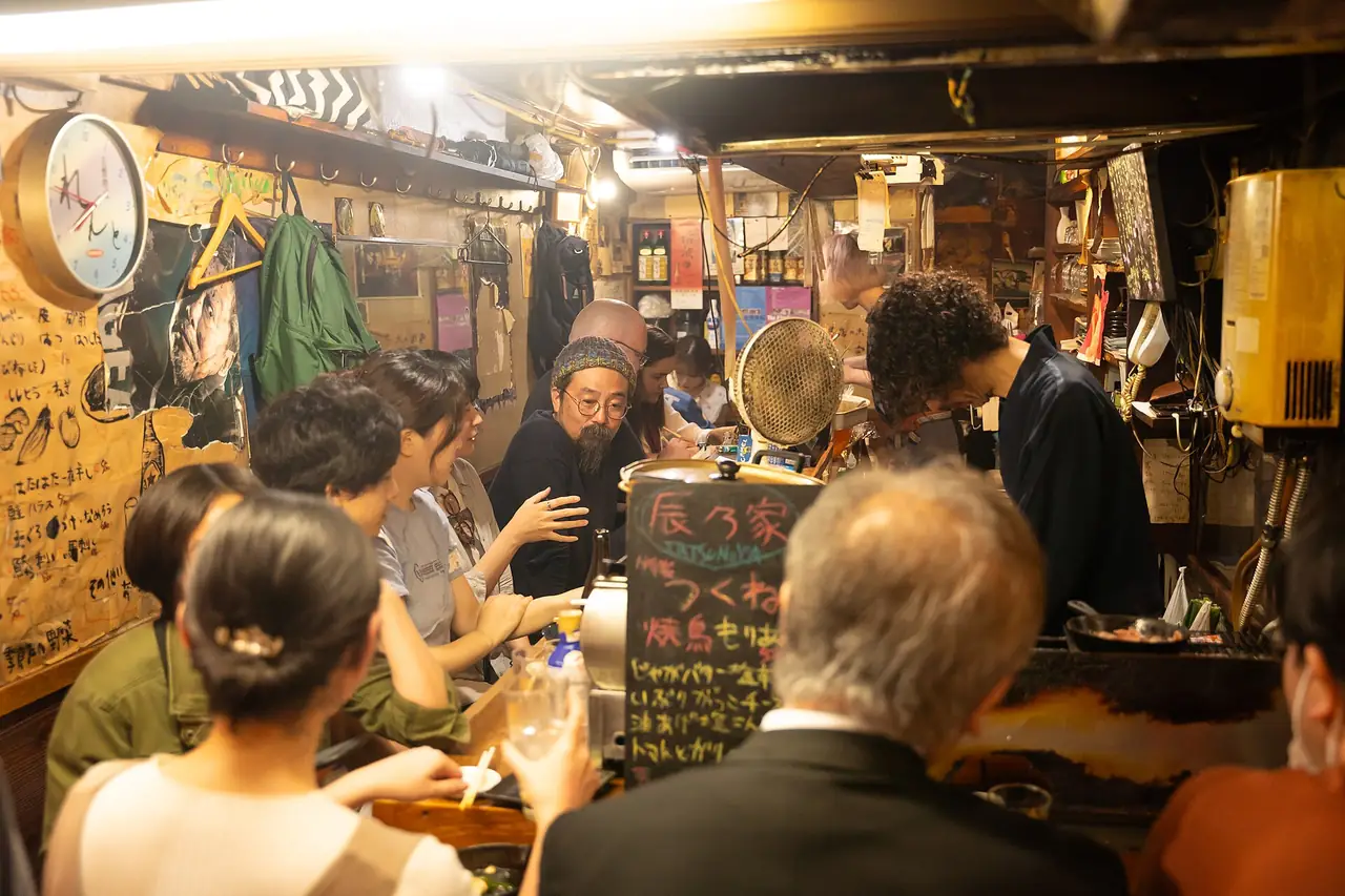 Diners packed around a small yakitori counter in Omoide Yokocho, Shinjuku