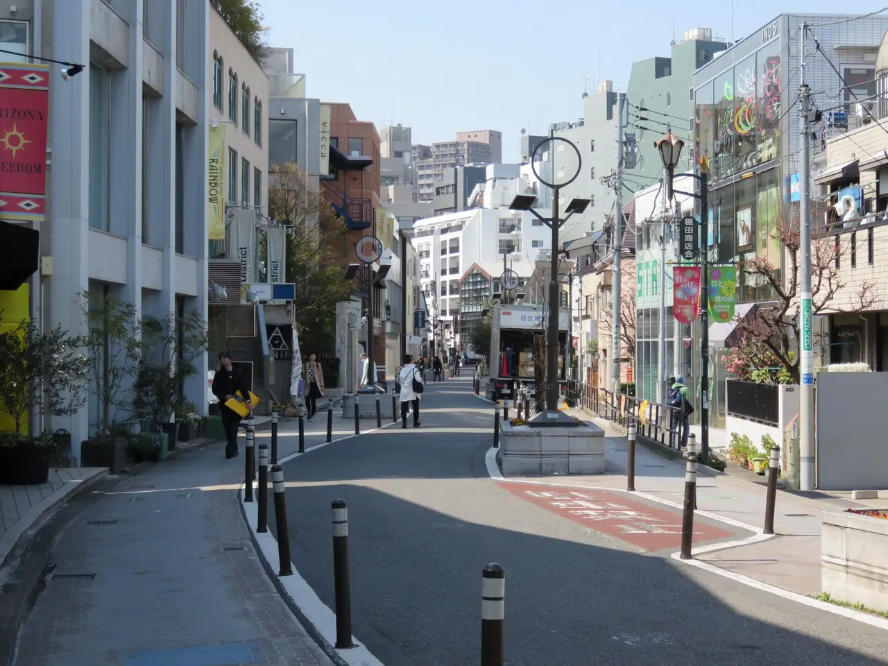 Shops and low buildings along the curving pedestrian lane of Cat Street