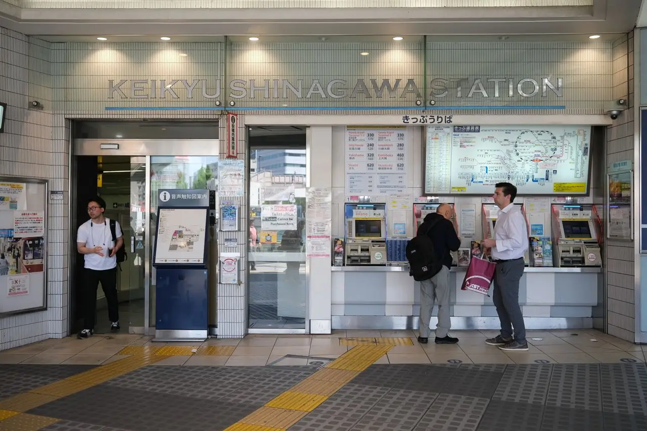 Travelers buying train tickets at the machines in Keikyu Shinagawa Station