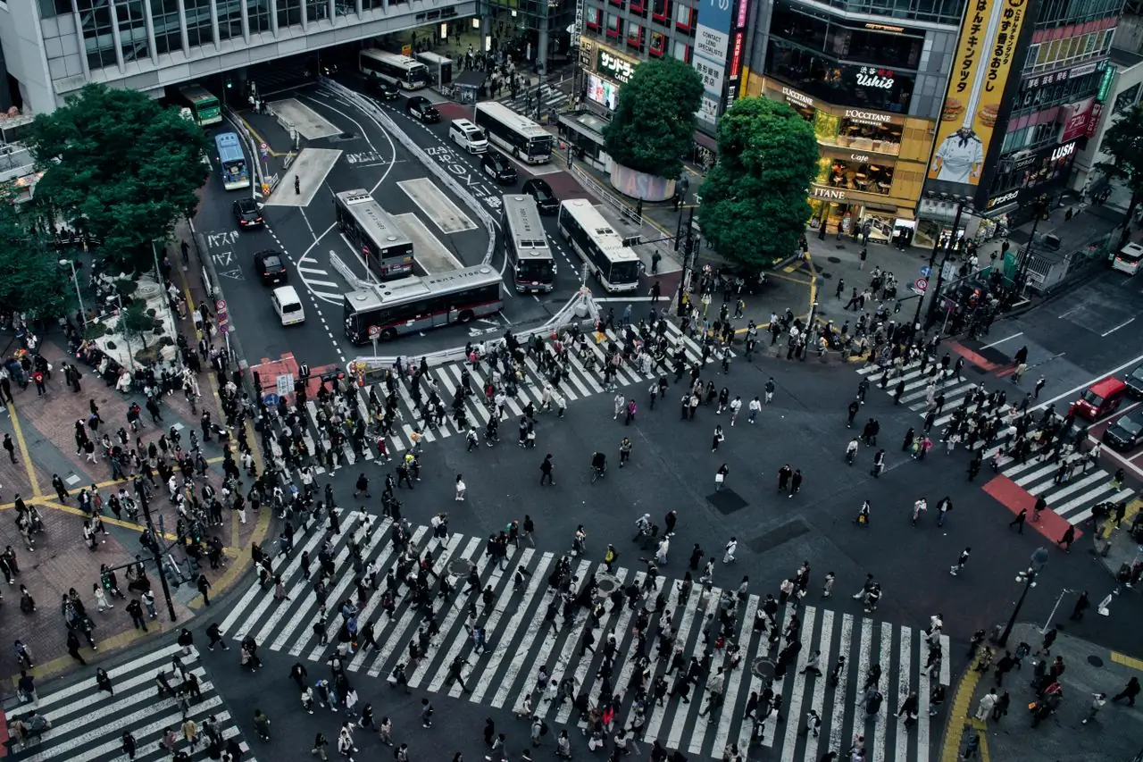 Pedestrians streaming across Shibuya Crossing from every direction