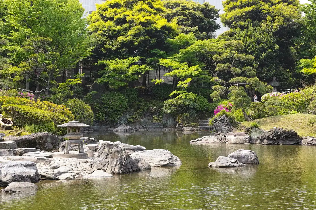 Stone lantern and rocks on the tidal pond of Kyu-Yasuda Garden in spring