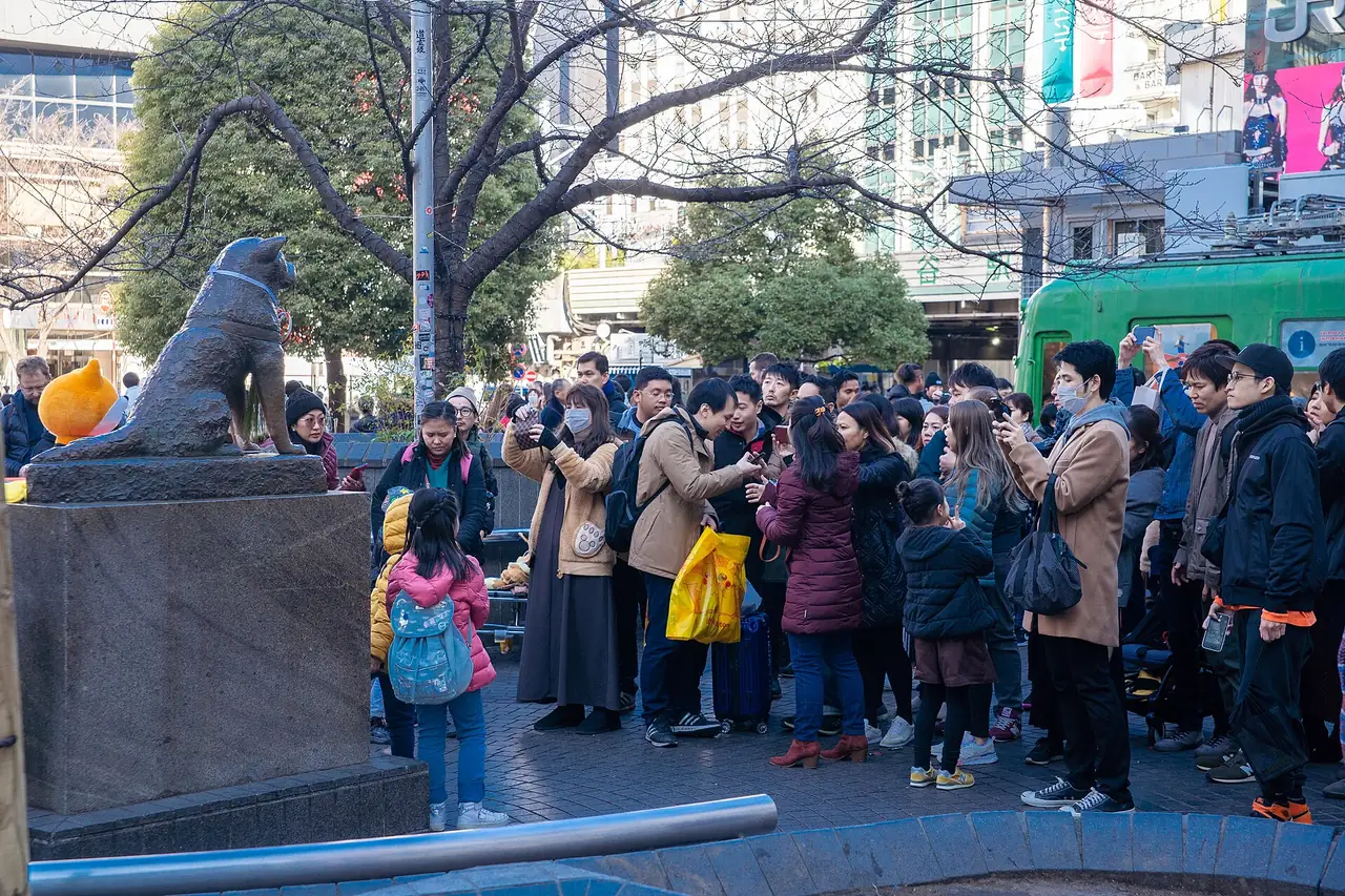 Crowds gathered beside the Hachiko statue, a popular meeting spot outside Shibuya Station
