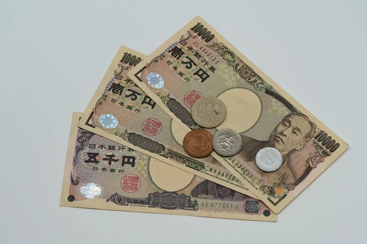 Japanese 10,000 and 5,000 yen banknotes with a few coins on a table