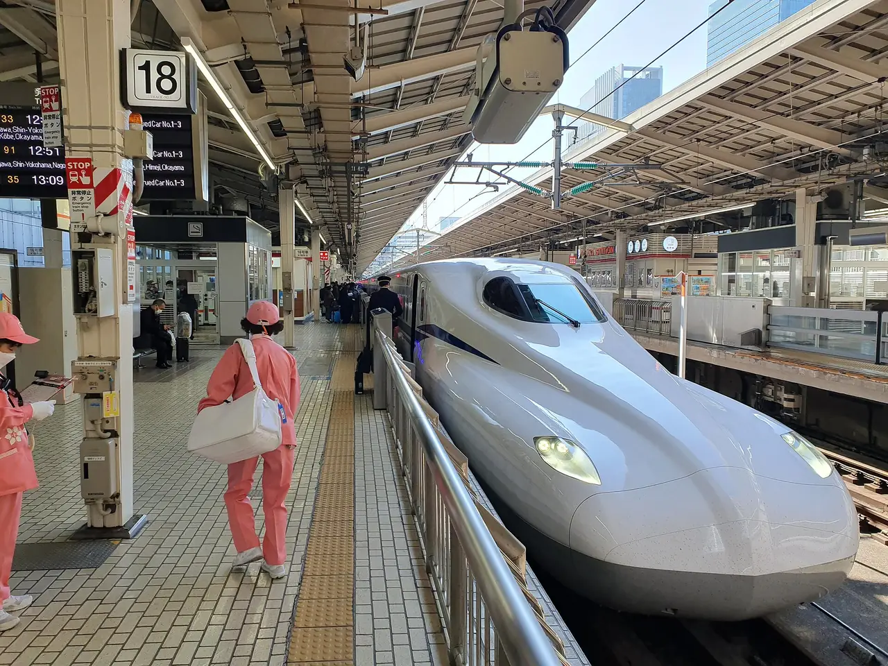N700S Shinkansen at platform 18 of Tokyo Station with cleaning staff waiting