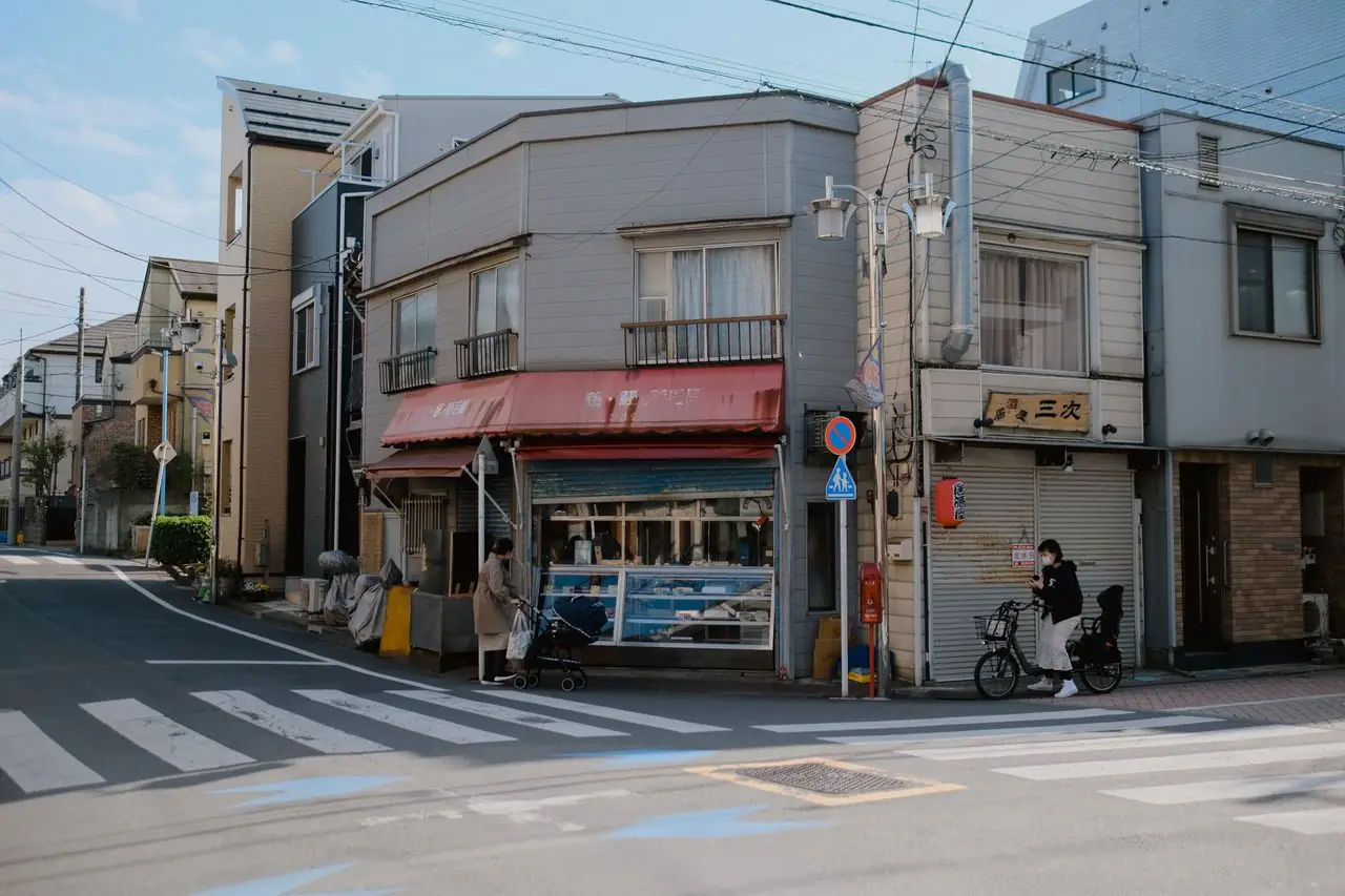 A small corner shop at a quiet neighborhood crossroads in Tokyo