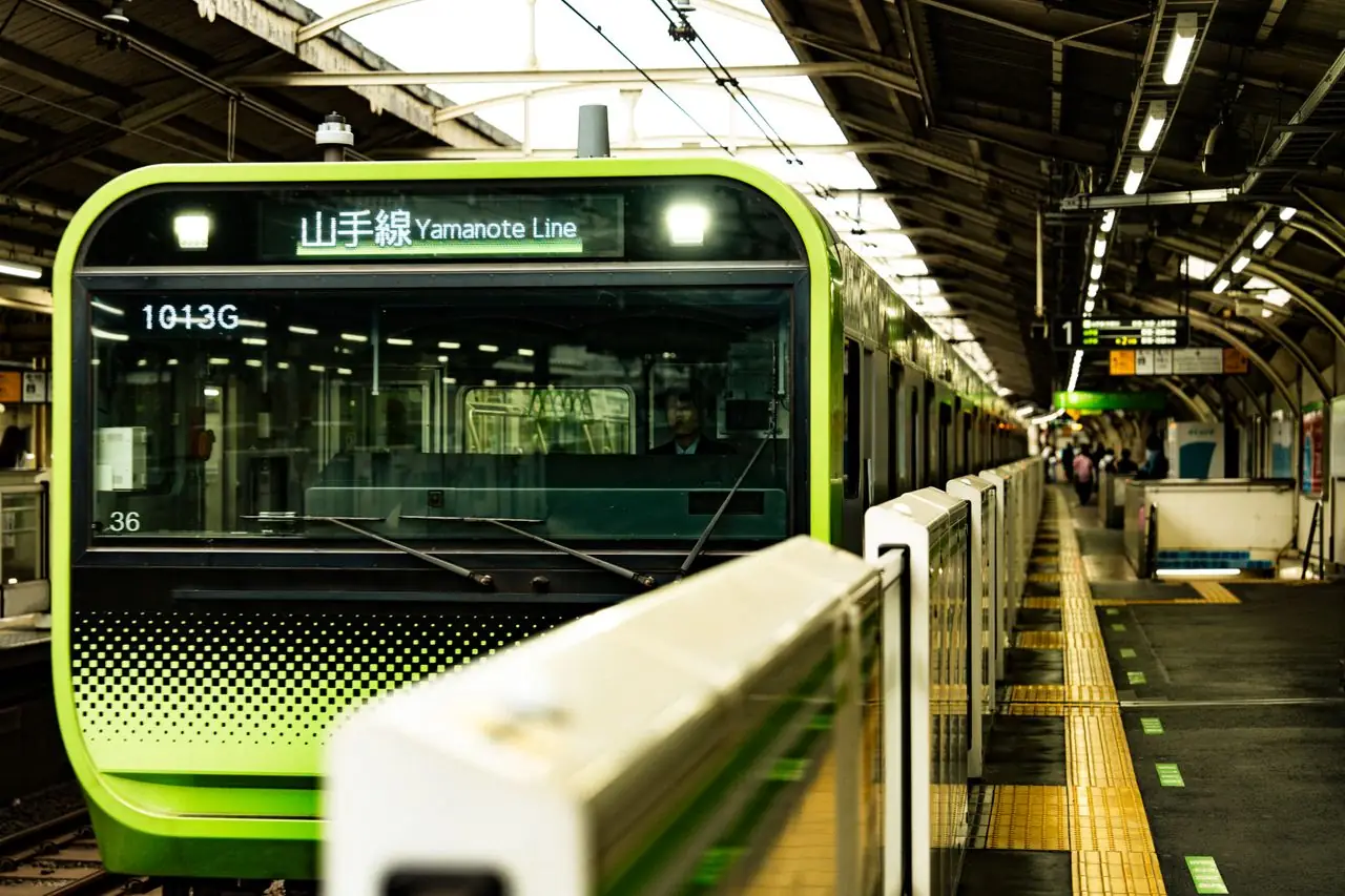 A green Yamanote Line train waiting at a platform in a Tokyo station