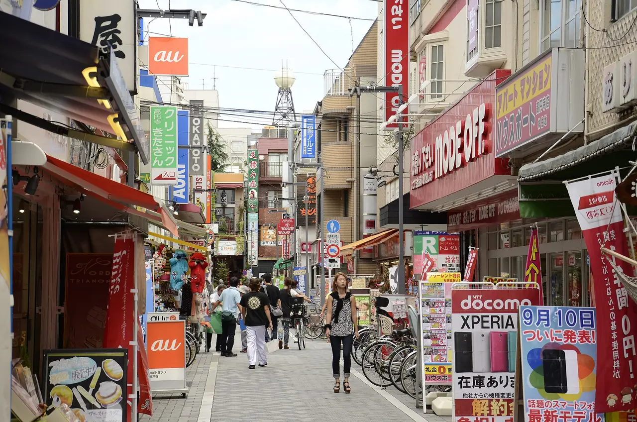 Shop signs and parked bicycles along a busy neighborhood shopping street in Tokyo