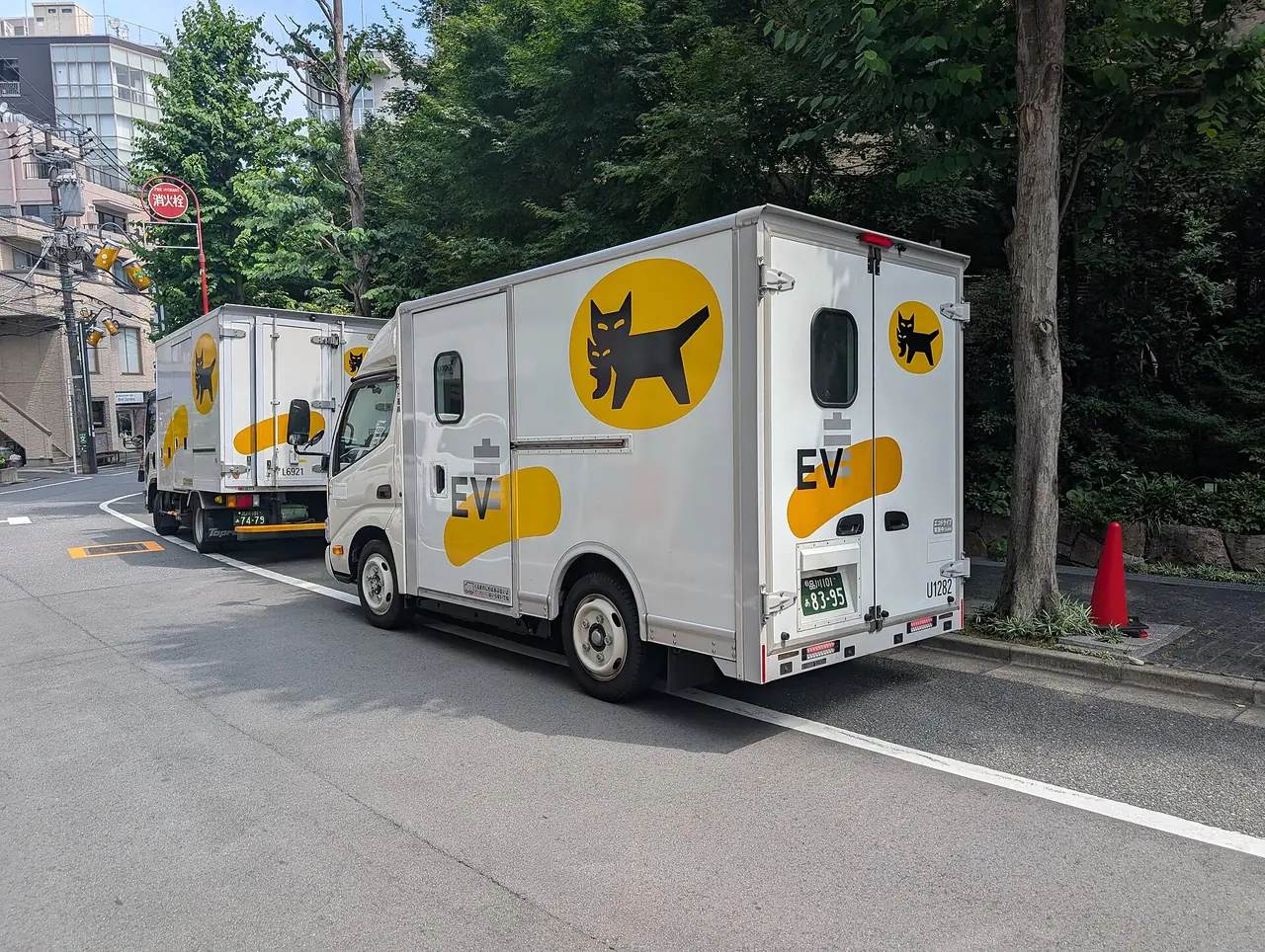 Kuroneko Yamato delivery trucks with the black cat logo parked on a street