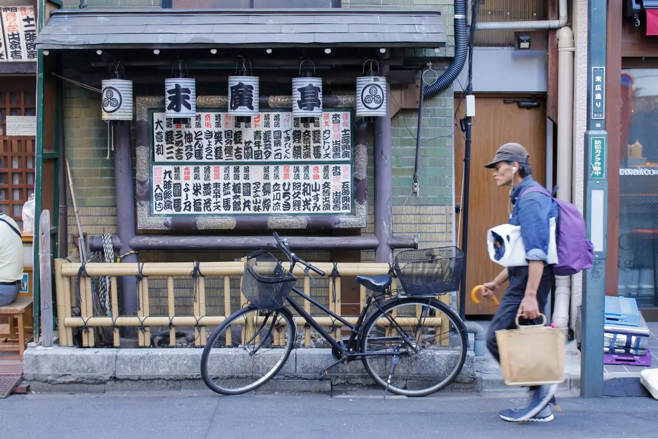 A pedestrian passing the lantern-hung front of the Suehirotei rakugo theater in Shinjuku