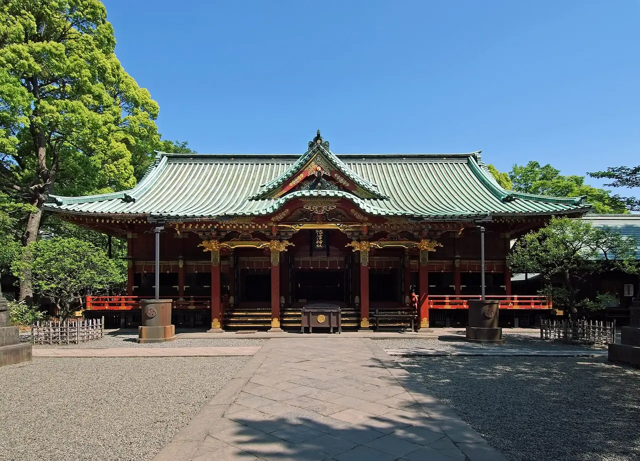 Vermilion and gold worship hall of Nezu Shrine under a green copper roof