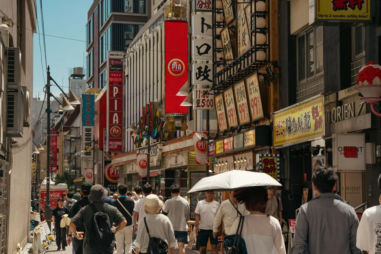 Stacked vertical signs for upper-floor businesses above a busy Tokyo street