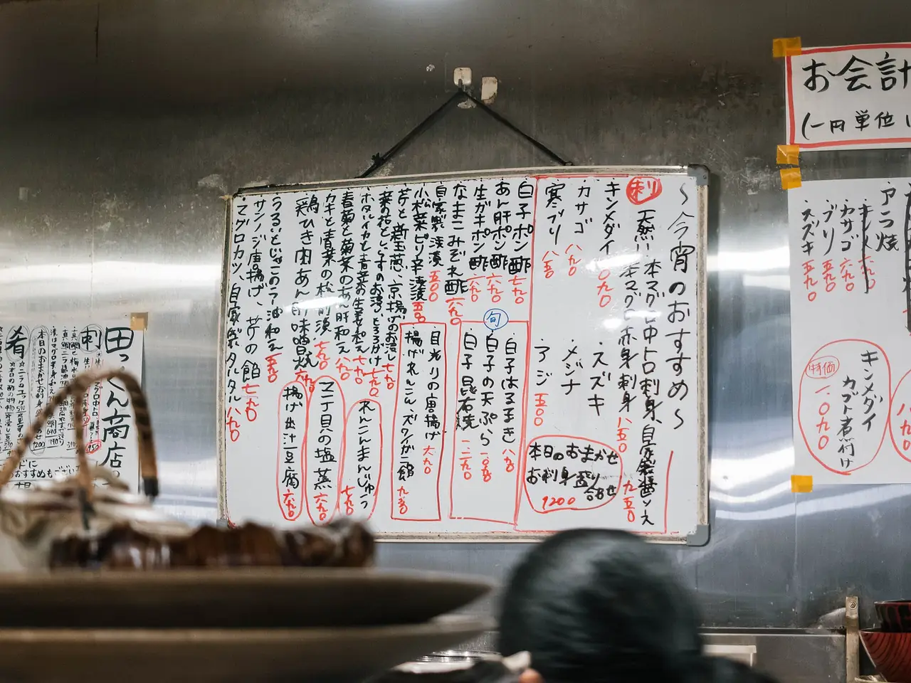 Handwritten whiteboard of the evening specials on the wall of a Japanese izakaya