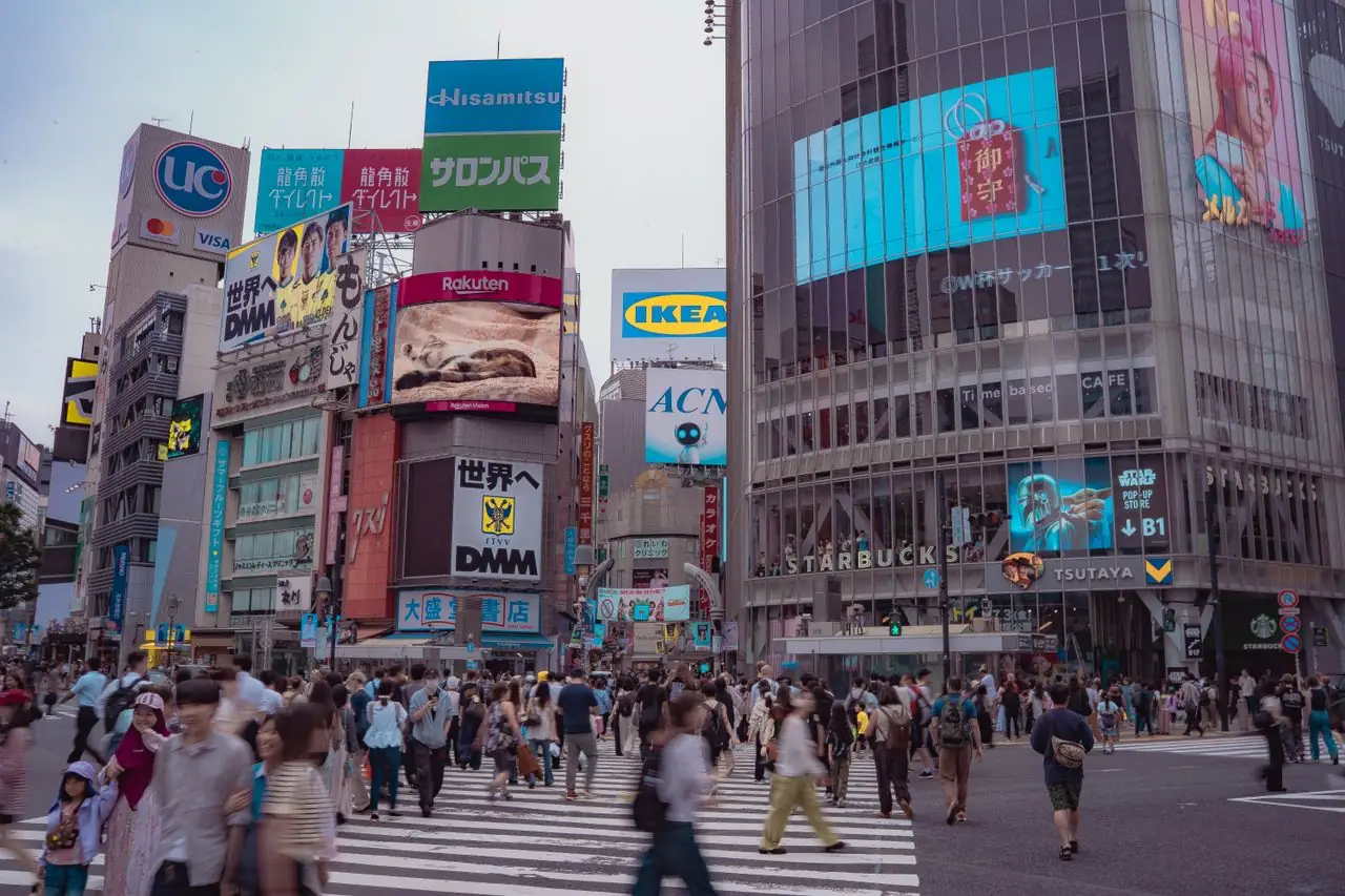 Early evening crowds walking across Shibuya Crossing at street level